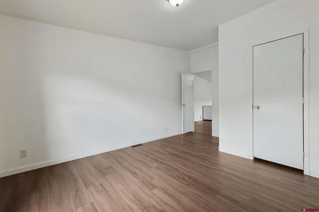 a view of an empty room and wooden floor