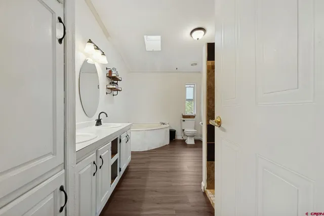a bathroom with a double vanity sink and mirror with shower
