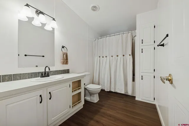 a bathroom with a double vanity sink toilet and shower