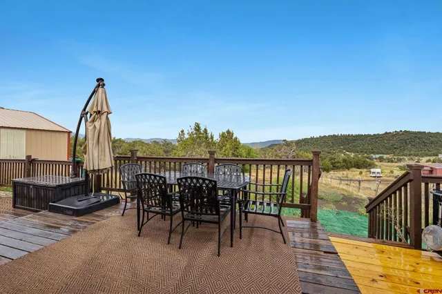 a view of a balcony with table and chairs and wooden fence