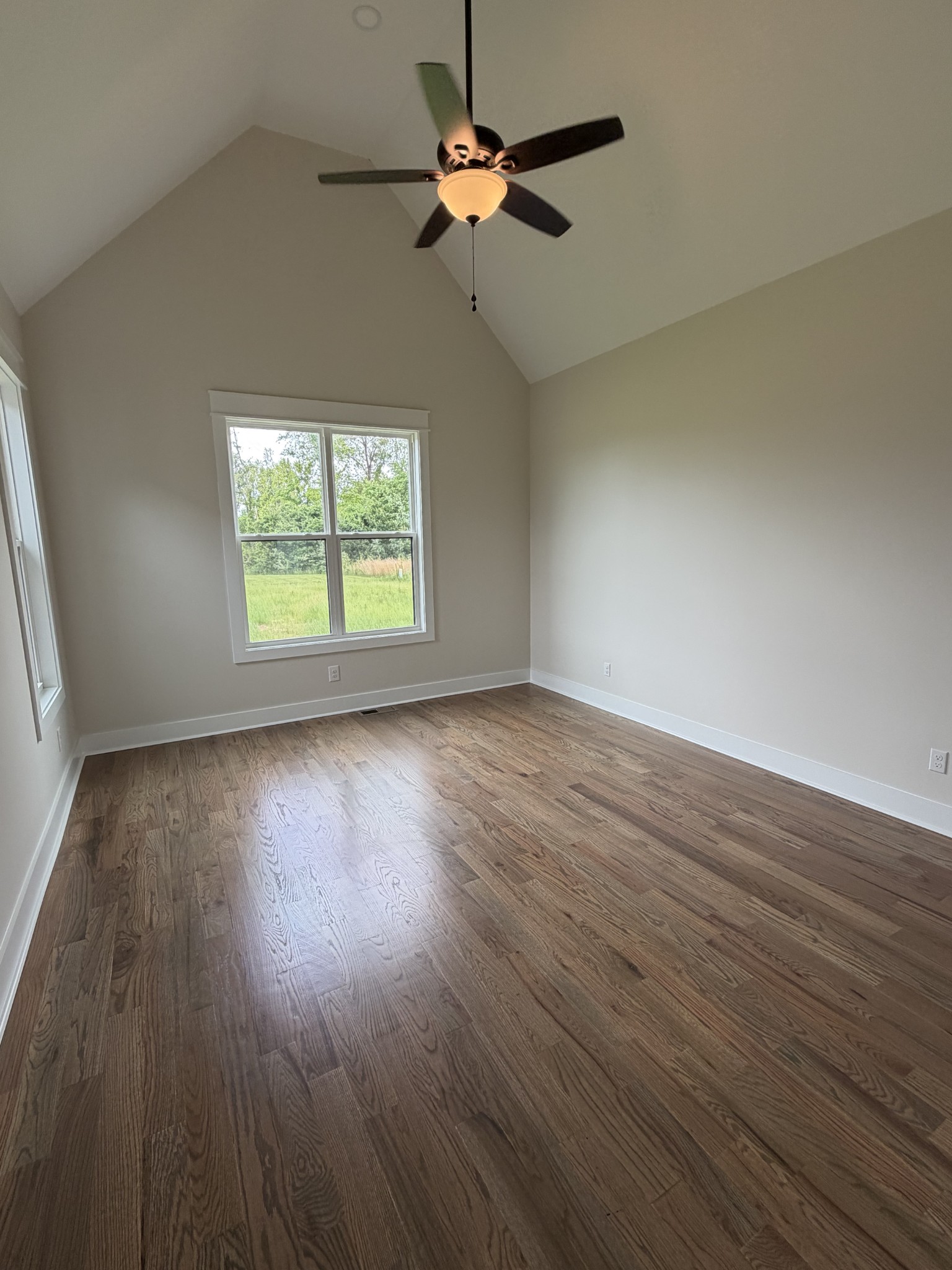 1258 Tom Grissom Road Morrison, TN 37357 - Photo 6 of 8 an empty room with wooden floor chandelier fan and windows