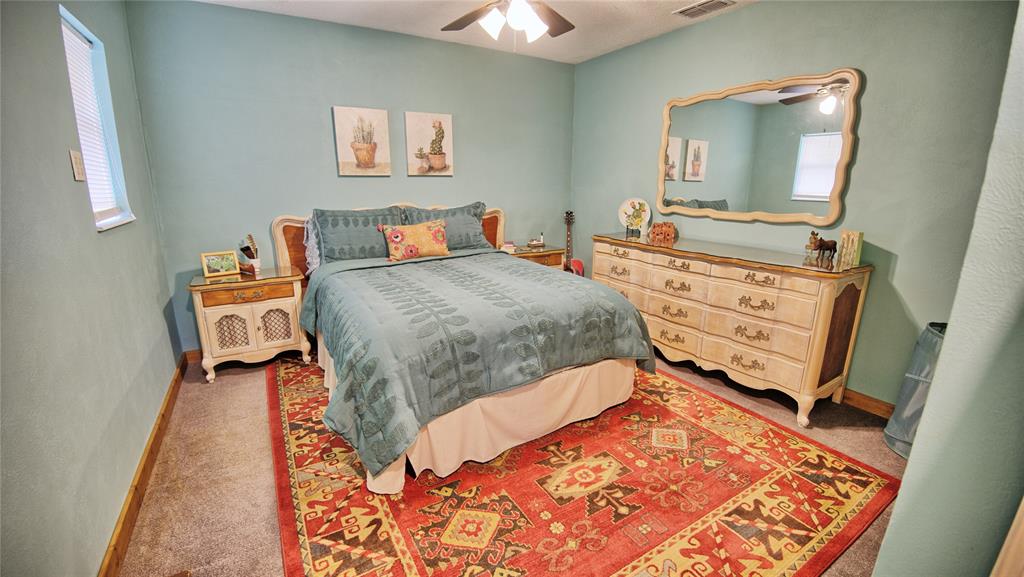 858 Ford Road Bowie, TX 76230 - Photo 14 of 40 a bed room with a bed and a mirror