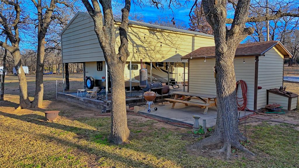 858 Ford Road Bowie, TX 76230 - Photo 16 of 40 a view of a house with backyard and a tree