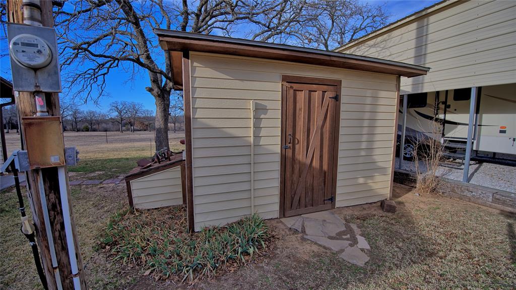 858 Ford Road Bowie, TX 76230 - Photo 37 of 40 a backyard of a house with barbeque oven table and chairs