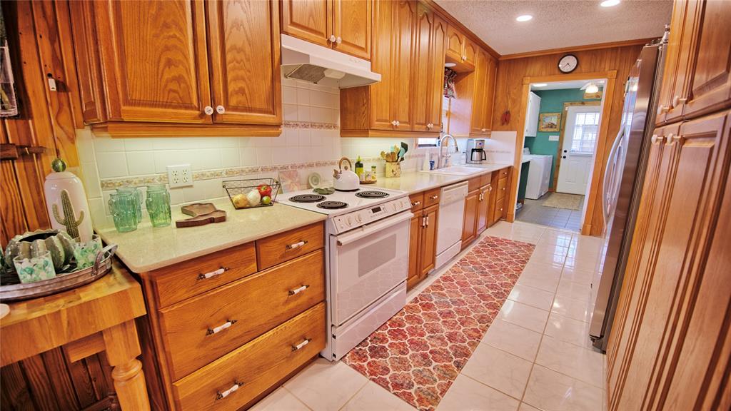 858 Ford Road Bowie, TX 76230 - Photo 5 of 40 a kitchen with a sink stove and cabinets