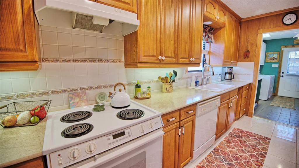 858 Ford Road Bowie, TX 76230 - Photo 6 of 40 a kitchen with kitchen island a sink a stove and wooden floor
