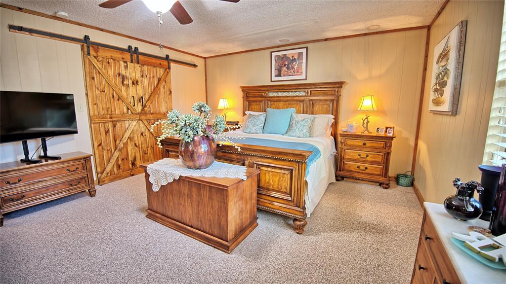 858 Ford Road Bowie, TX 76230 - Photo 8 of 40 a bedroom with furniture and a flat screen tv