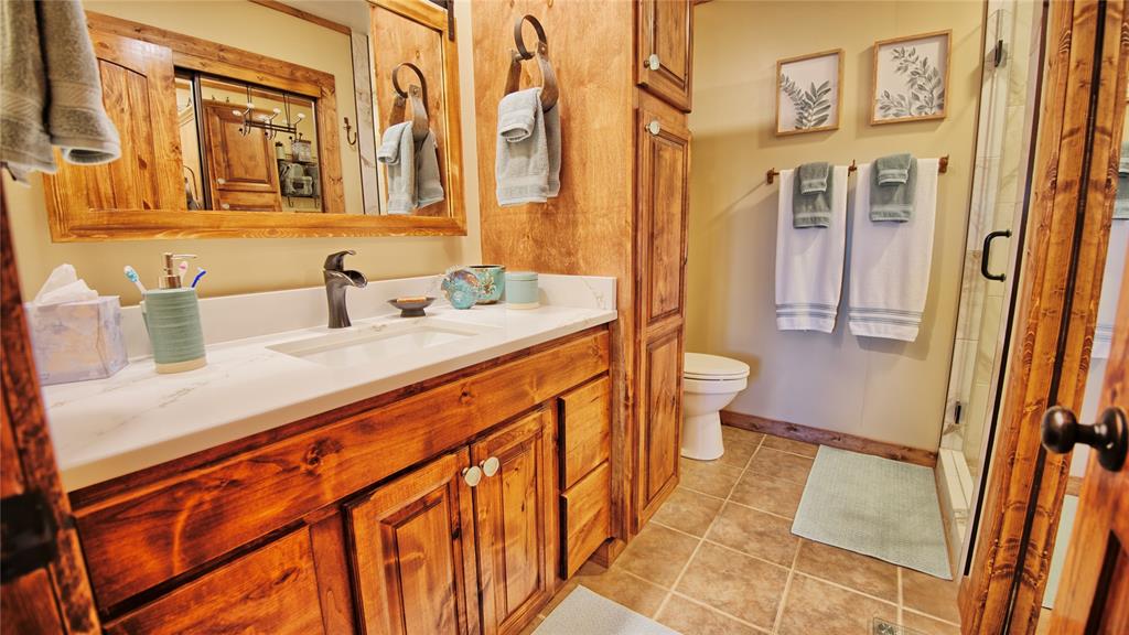 858 Ford Road Bowie, TX 76230 - Photo 9 of 40 a bathroom with a sink a toilet and shower
