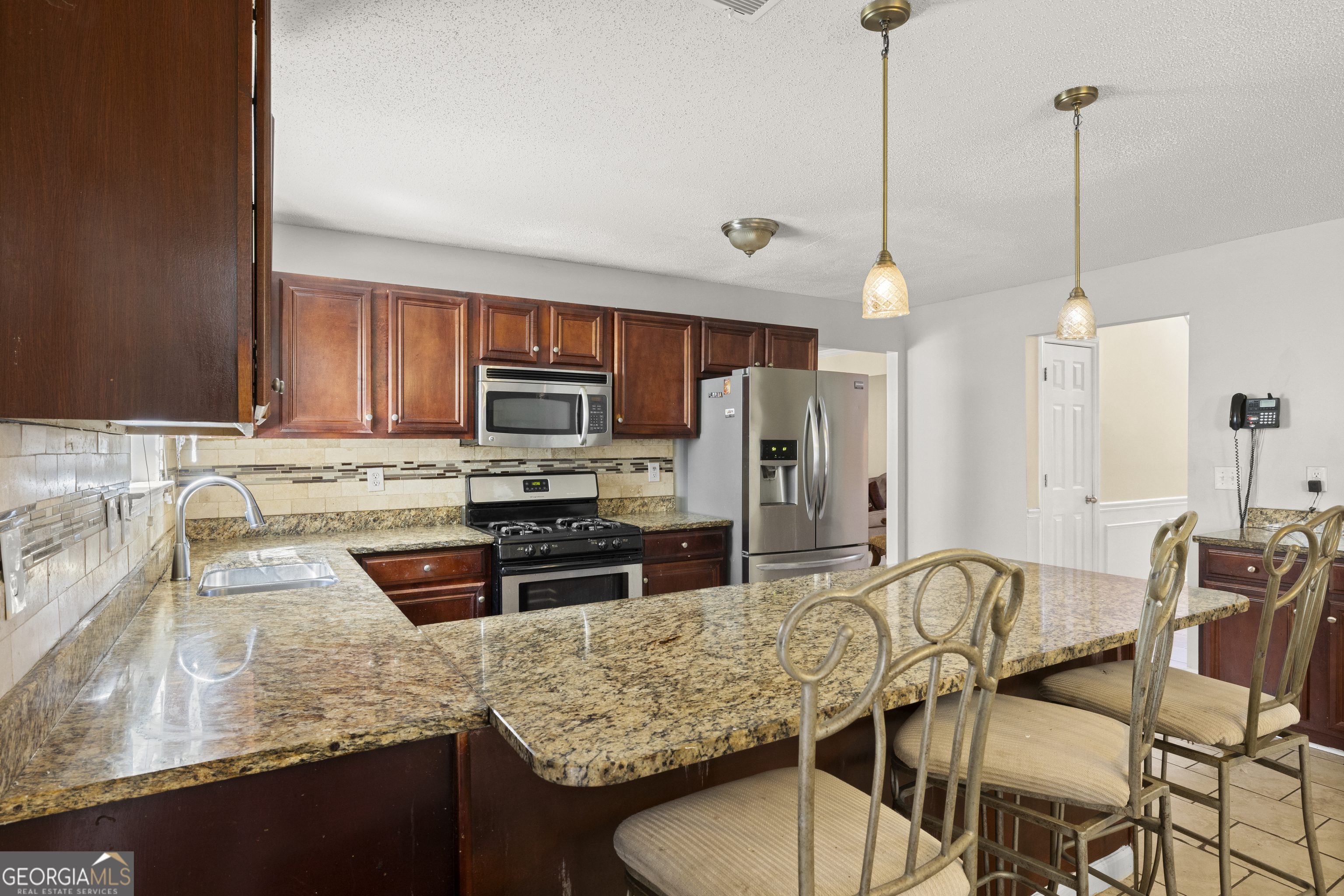 11961 Markham Way Hampton, GA 30228 - Photo 14 of 49 a kitchen with stainless steel appliances granite countertop a stove a refrigerator a sink a stove with a dining table and chairs