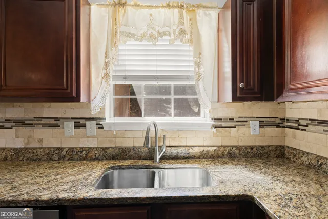 a kitchen with granite countertop a sink and a stove