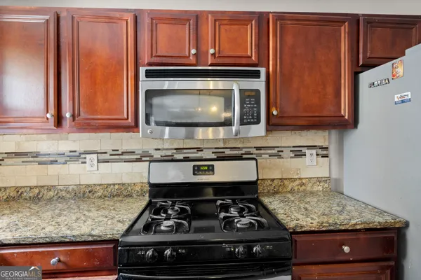 a kitchen with stainless steel appliances granite countertop a stove and a microwave