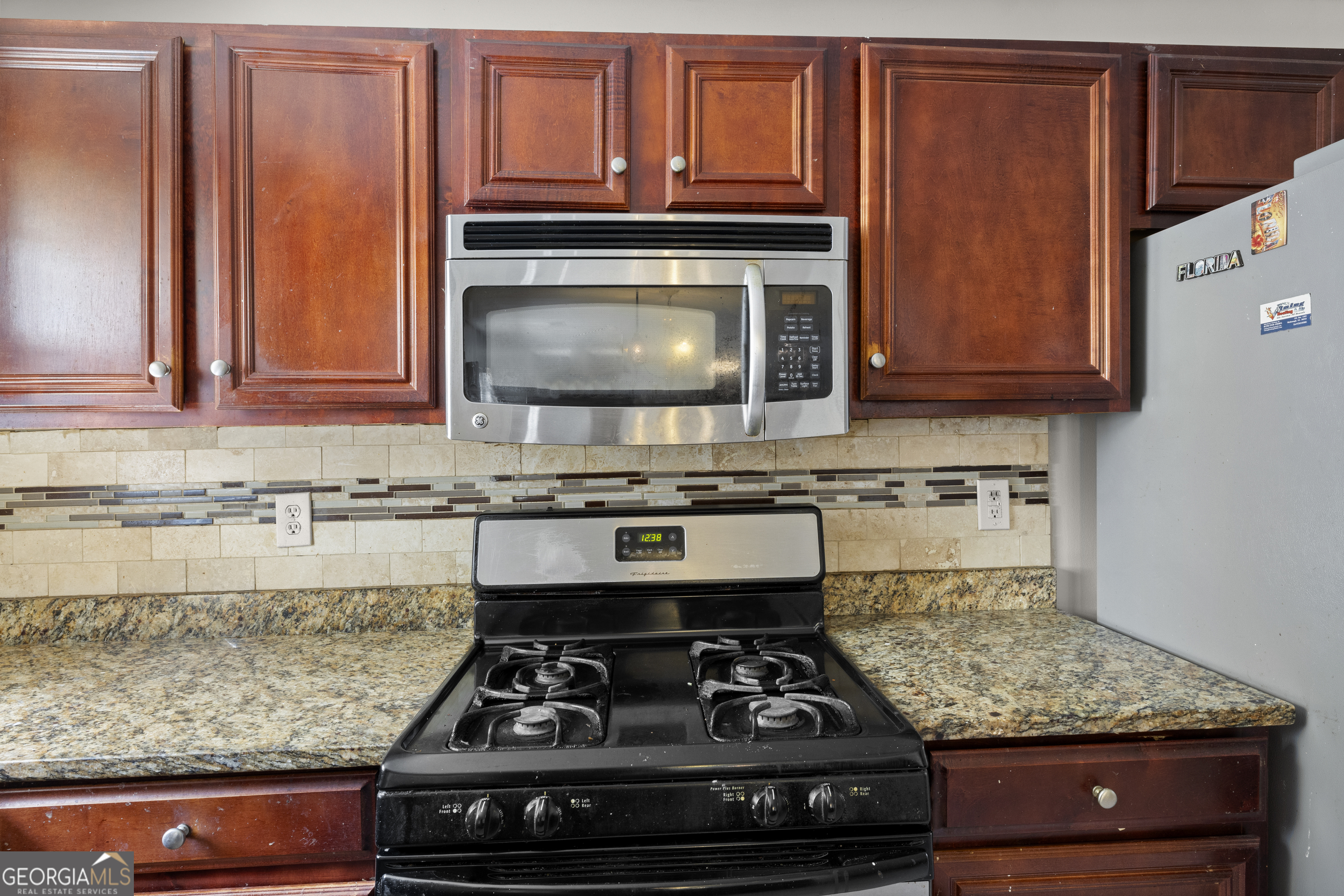 11961 Markham Way Hampton, GA 30228 - Photo 18 of 49 a kitchen with stainless steel appliances granite countertop a stove and a microwave