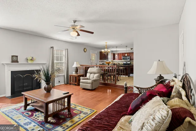 a living room with furniture a fireplace and a chandelier