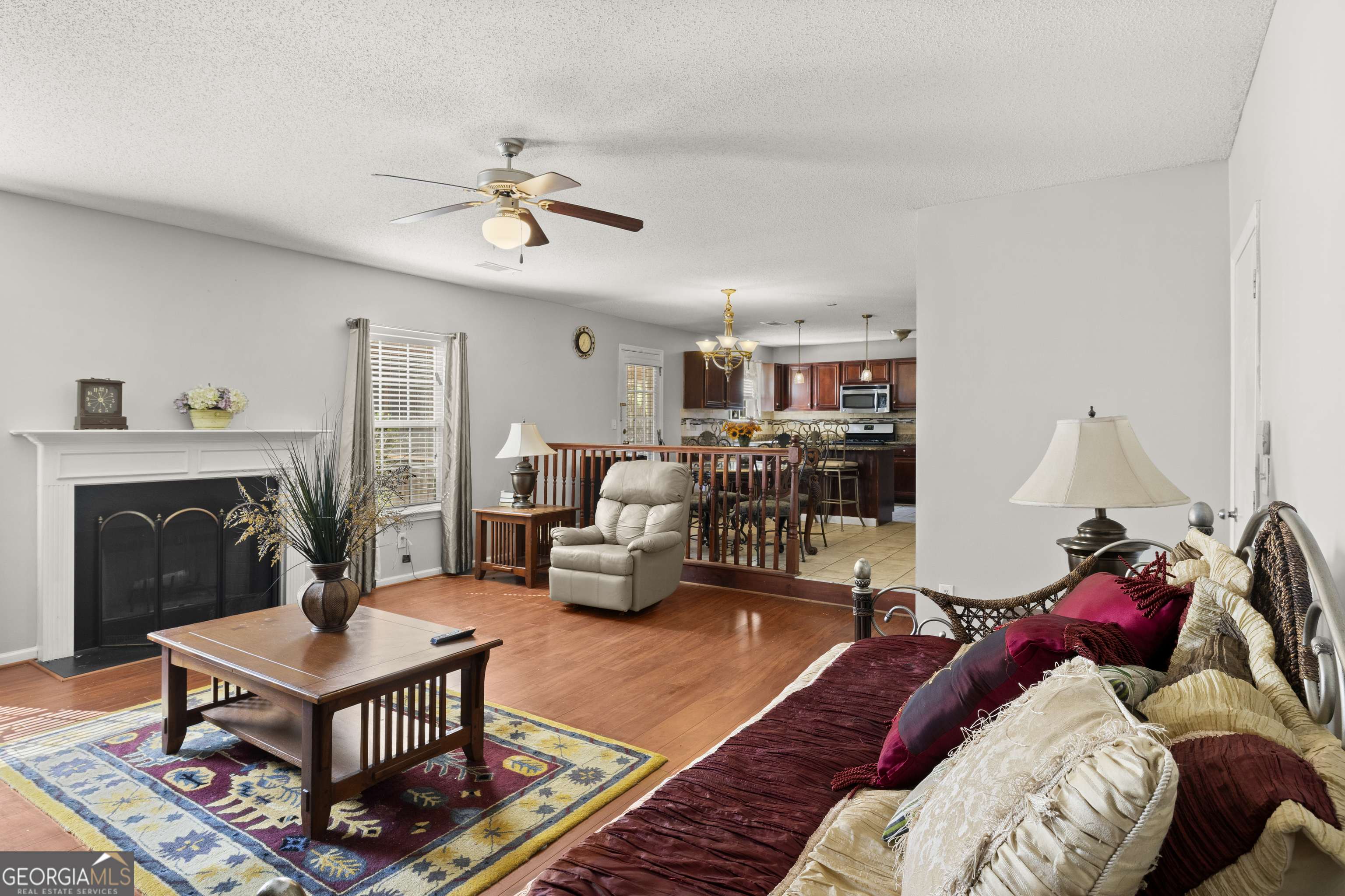 11961 Markham Way Hampton, GA 30228 - Photo 19 of 49 a living room with furniture a fireplace and a chandelier