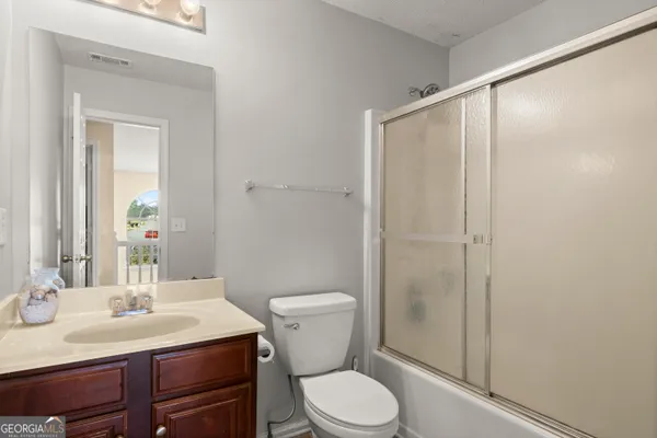a bathroom with a sink a toilet a mirror and shower