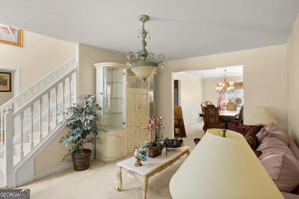a living room with furniture and a chandelier
