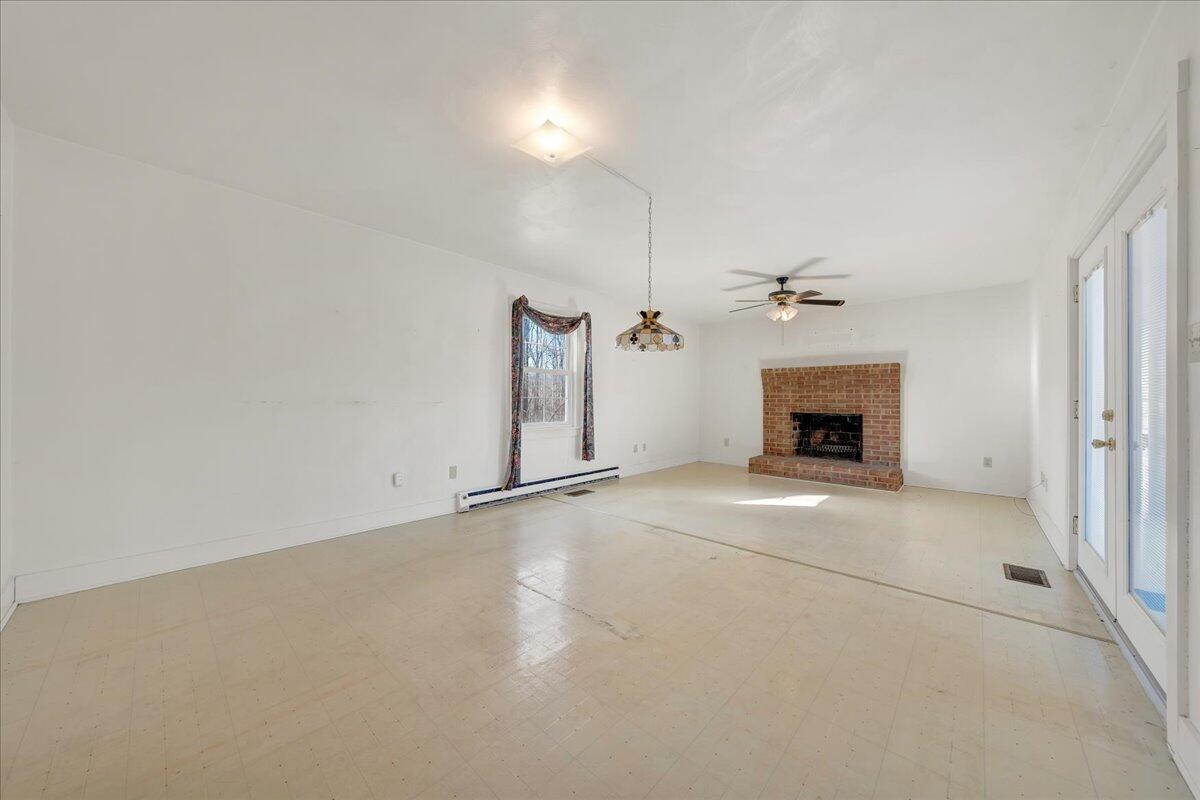 1391 Deep Woods Road Hardy, VA 24101 - Photo 22 of 43 an empty room with a fireplace and fan