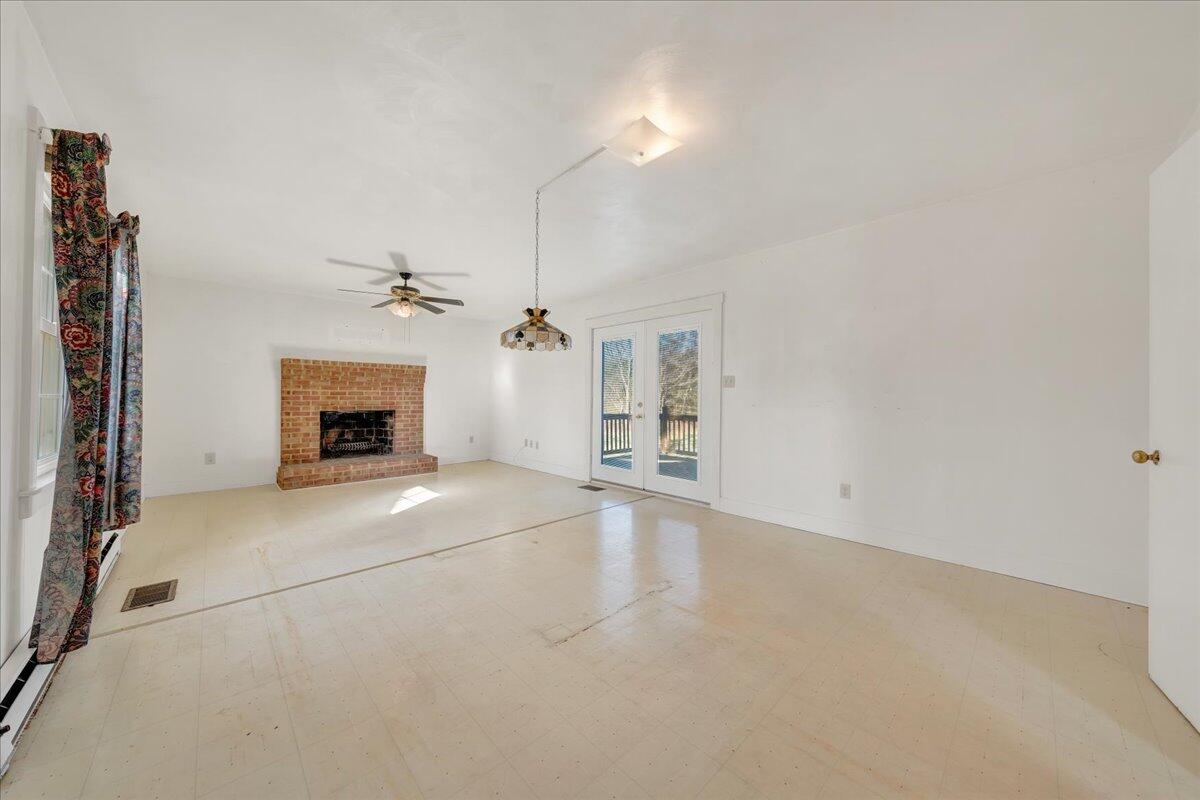 1391 Deep Woods Road Hardy, VA 24101 - Photo 23 of 43 an empty room with a fireplace and fan