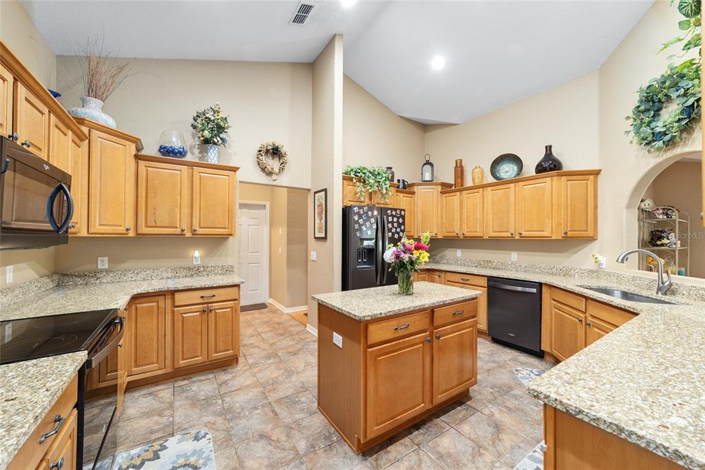 2151 Southeast 59th Street Ocala, FL 34480 - Photo 15 of 72 a kitchen with stainless steel appliances granite countertop a sink stove and refrigerator