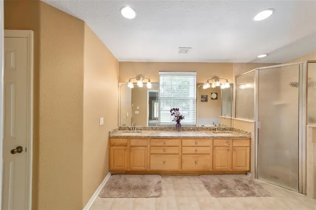 a bathroom with a double vanity sink toilet and a mirror