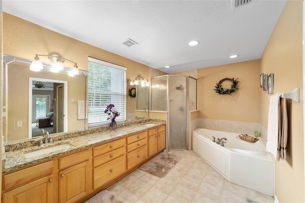 2151 Southeast 59th Street Ocala, FL 34480 - Photo 25 of 72 a bathroom with a granite countertop sink a toilet a mirror and shower