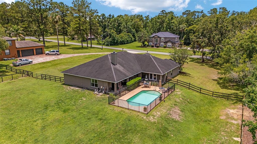 2151 Southeast 59th Street Ocala, FL 34480 - Photo 48 of 72 an aerial view of a house with swimming pool and large trees