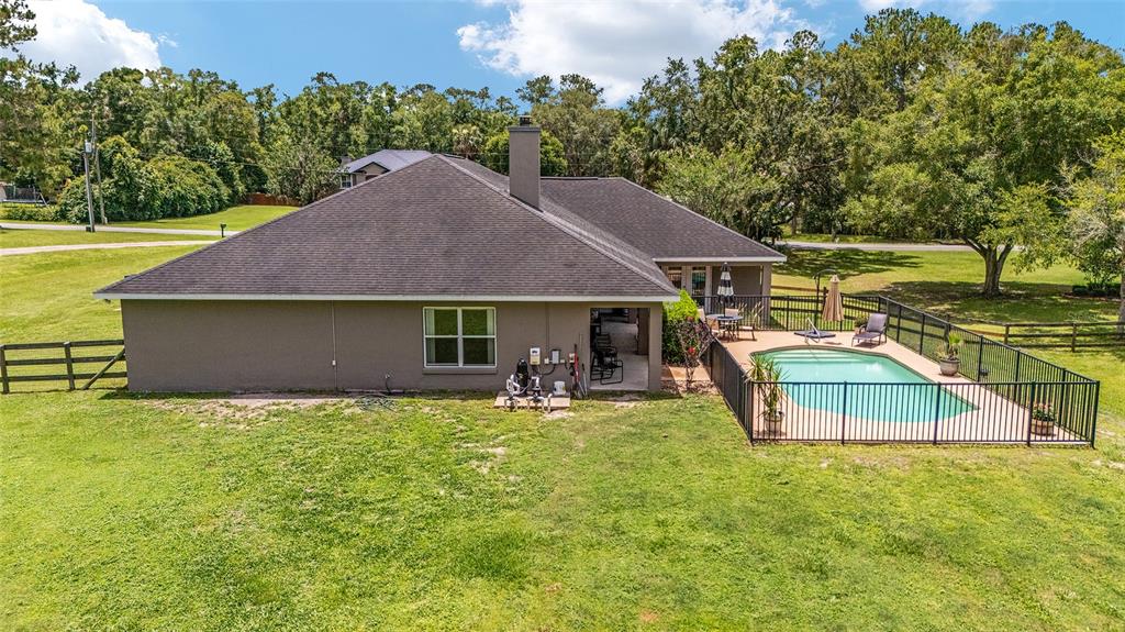 2151 Southeast 59th Street Ocala, FL 34480 - Photo 50 of 72 a backyard of a house with table and chairs under an umbrella