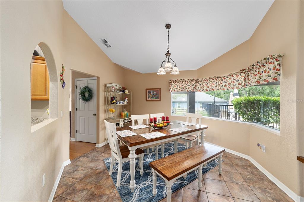 2151 Southeast 59th Street Ocala, FL 34480 - Photo 63 of 72 a dining room with furniture a chandelier and wooden floor