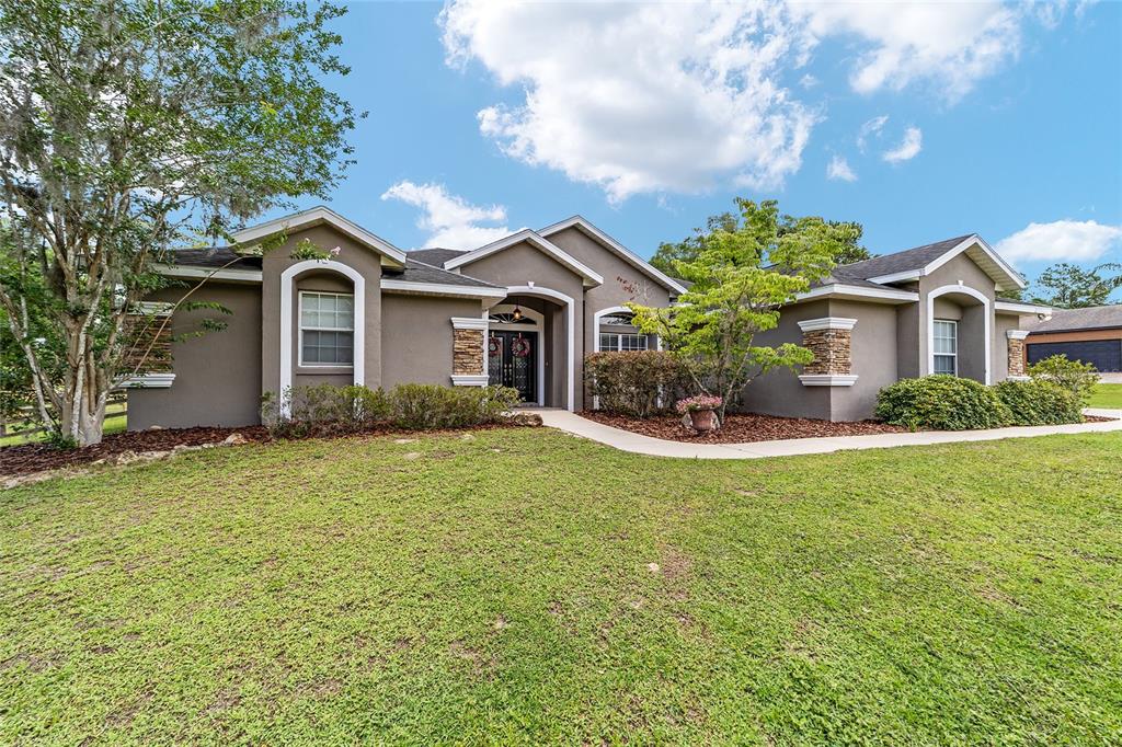 2151 Southeast 59th Street Ocala, FL 34480 - Photo 64 of 72 a front view of a house with a garden