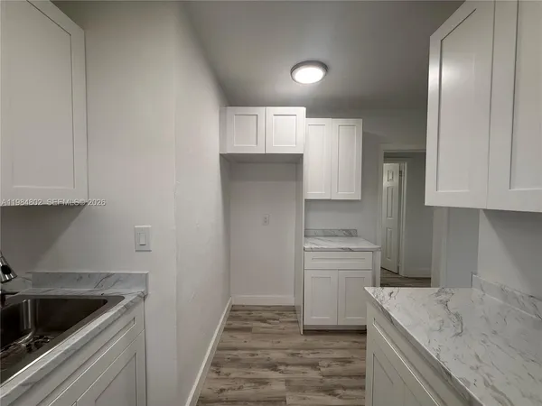 a kitchen with a refrigerator sink and cabinets