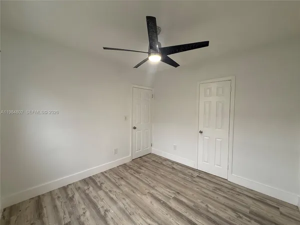 a view of empty room with wooden floor