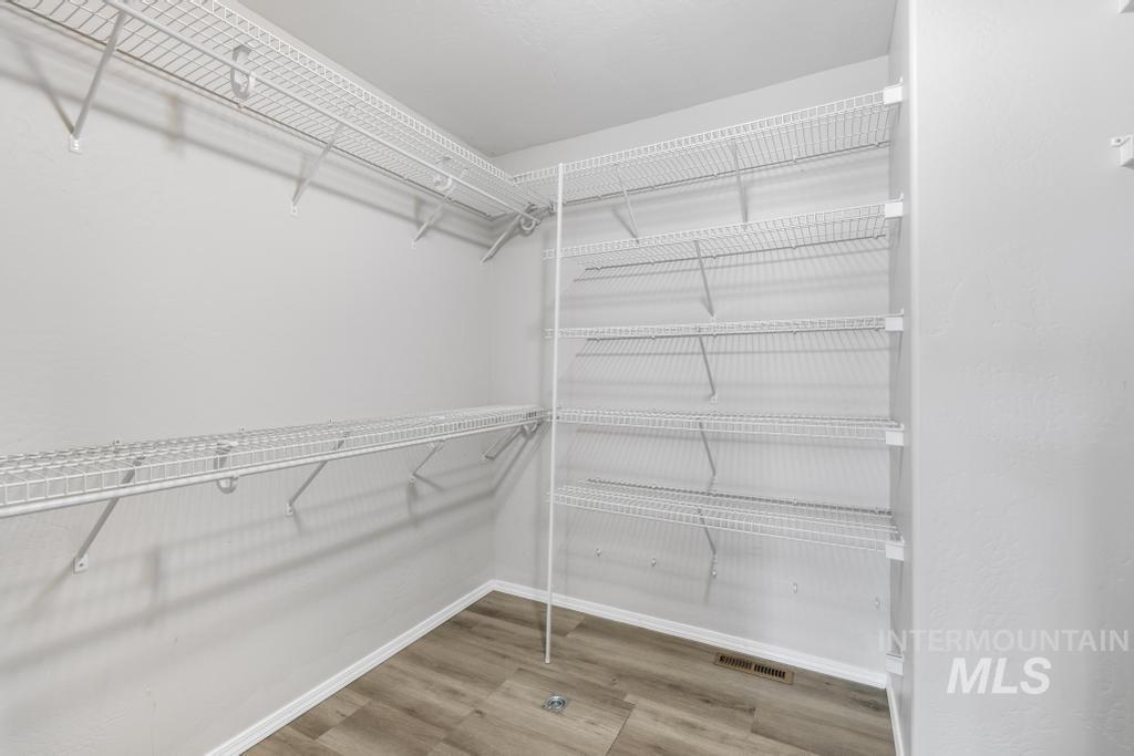 1183 Cortes Loop Twin Falls, ID 83301 - Photo 19 of 30 Walk-in closet featuring extensive wire shelving, white wall finishes, and wood-finish flooring
