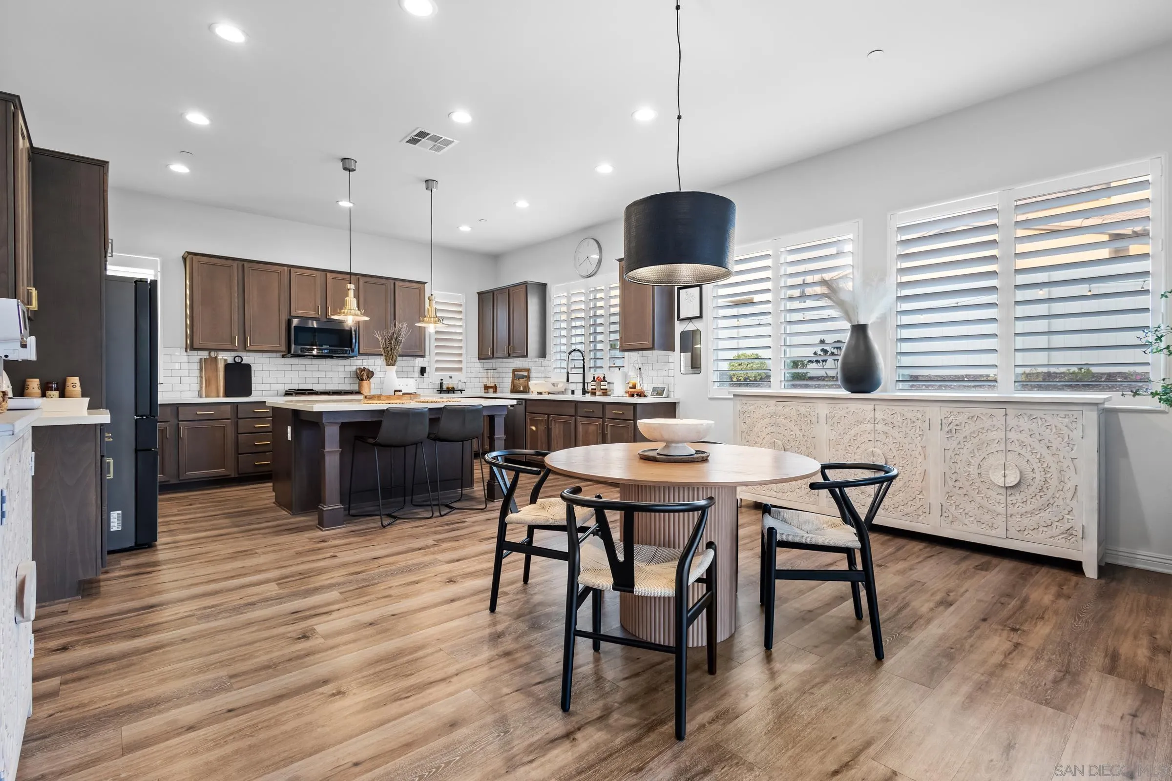 1853 Ashley Avenue Chula Vista, CA 91913 - Photo 8 of 73 a kitchen with stainless steel appliances kitchen island granite countertop a dining table chairs and a refrigerator