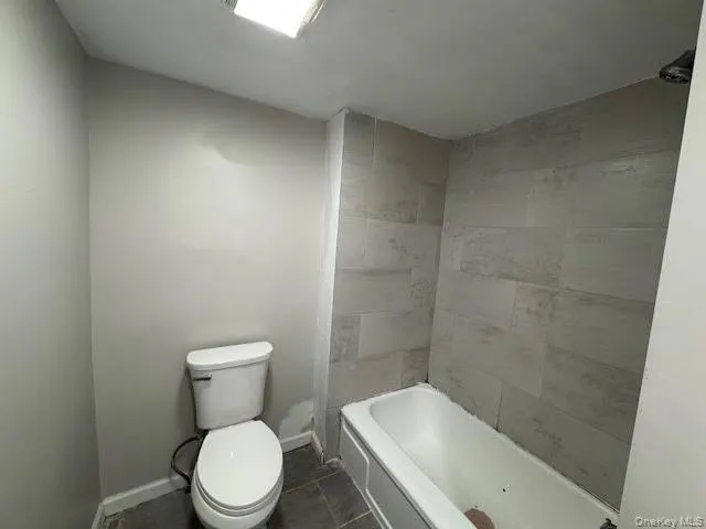 a white toilet sitting next to a bath tub
