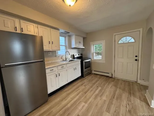 a kitchen with stainless steel appliances a refrigerator sink and cabinets