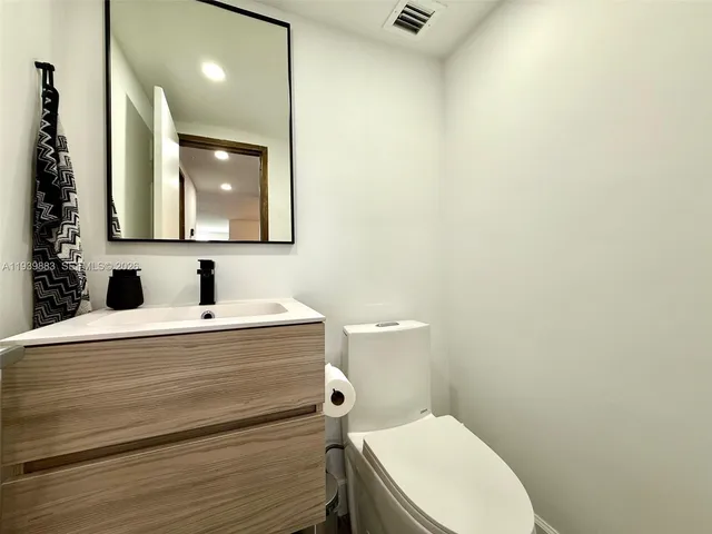 a bathroom with a sink a toilet and mirror