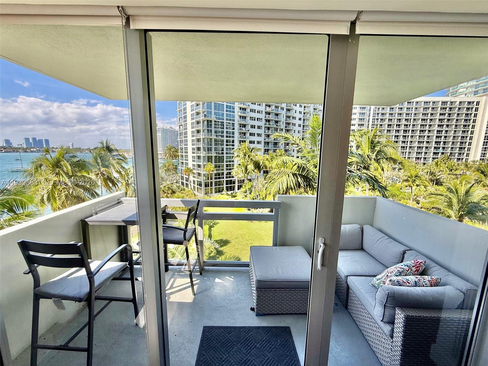 1500 Bay Road, Unit 540S Miami Beach, FL 33139 - Photo 2 of 40 a balcony with table and chairs