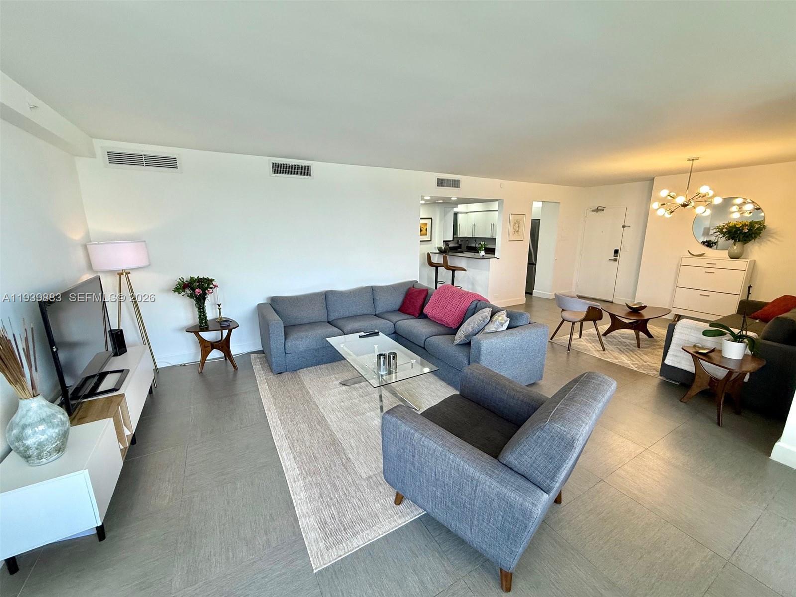 1500 Bay Road, Unit 540S Miami Beach, FL 33139 - Photo 6 of 40 a living room with furniture and a flat screen tv