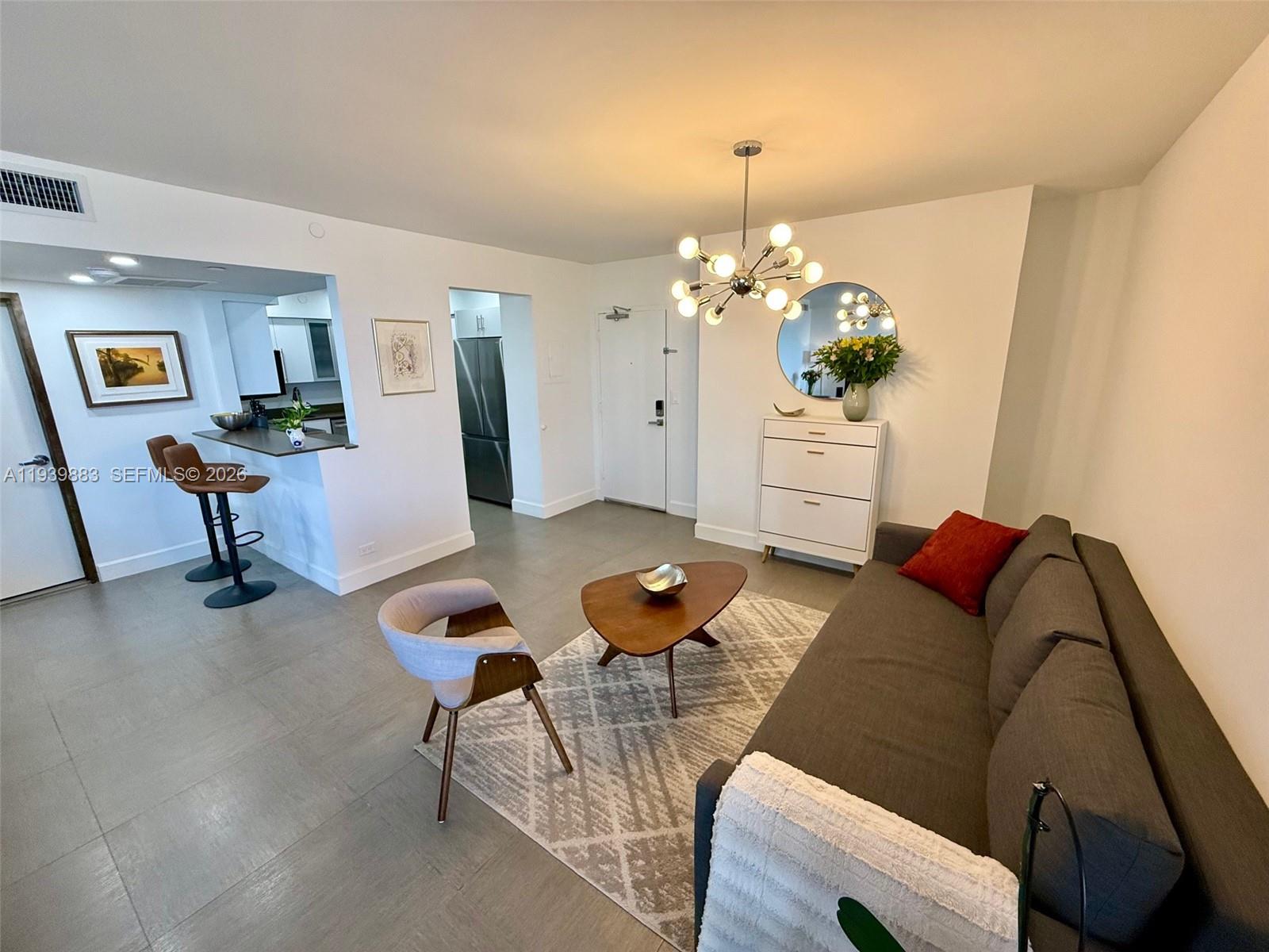 1500 Bay Road, Unit 540S Miami Beach, FL 33139 - Photo 7 of 40 a living room with furniture and a chandelier