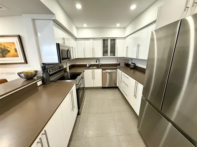 a kitchen with a sink stainless steel appliances a window and a counter top space