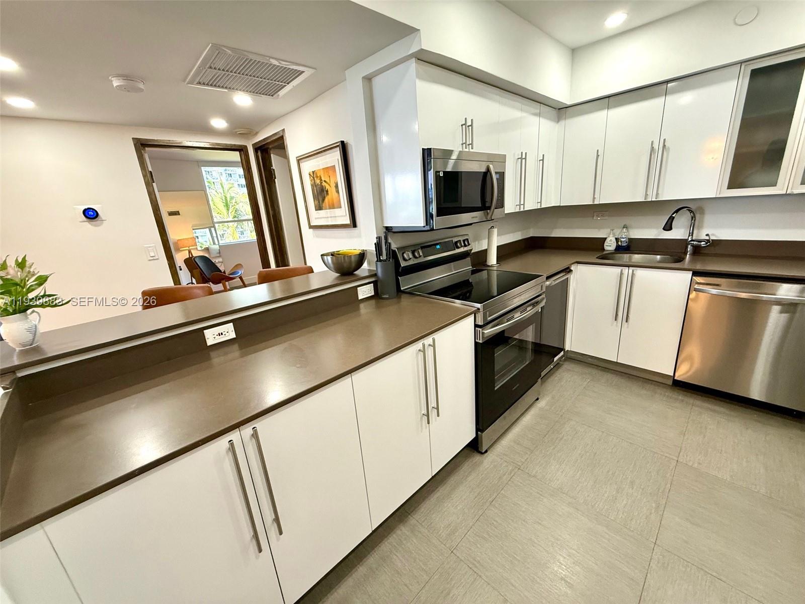 1500 Bay Road, Unit 540S Miami Beach, FL 33139 - Photo 10 of 40 a kitchen with a sink cabinets and stainless steel appliances