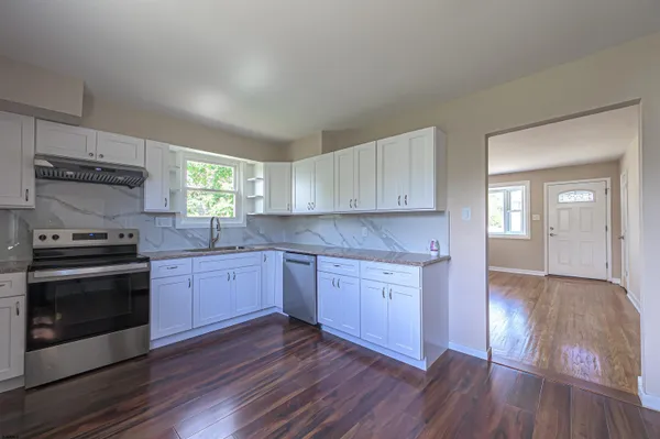 a kitchen with granite countertop wooden floors and stainless steel appliances