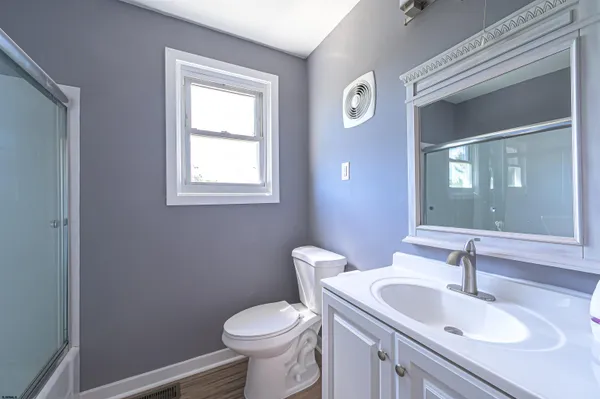 a bathroom with a sink a toilet and mirror