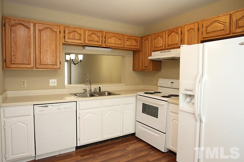 4635 Fawnbrook Circle Raleigh, NC 27612 - Photo 2 of 12 a kitchen with white cabinets and white appliances