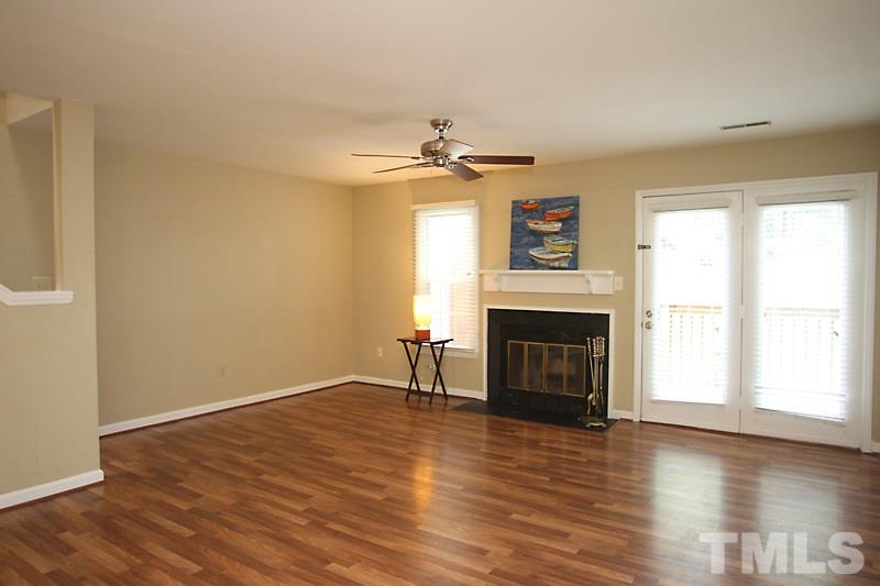 4635 Fawnbrook Circle Raleigh, NC 27612 - Photo 5 of 12 an empty room with windows a fireplace and wooden floor