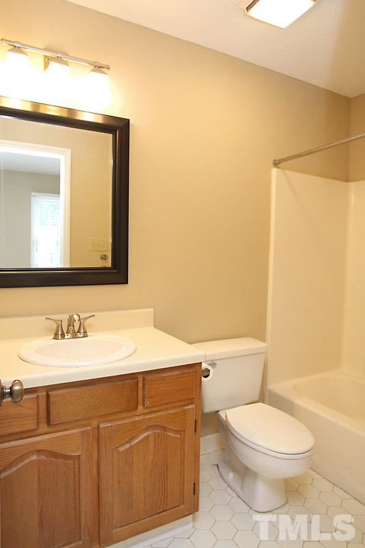 4635 Fawnbrook Circle Raleigh, NC 27612 - Photo 7 of 12 a bathroom with a toilet a sink and a mirror