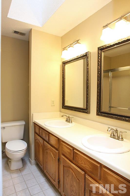 4635 Fawnbrook Circle Raleigh, NC 27612 - Photo 9 of 12 a bathroom with a granite countertop toilet sink and mirror