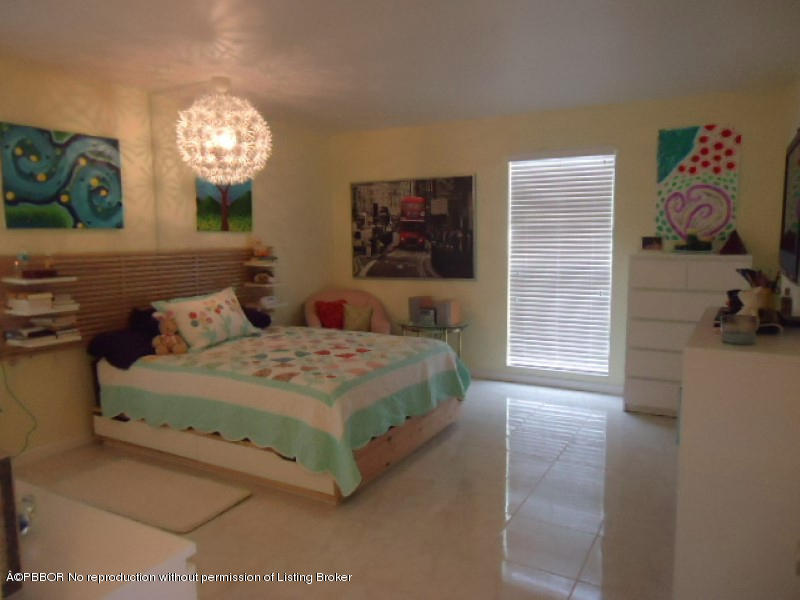 5 Little Pond Road Manalapan, FL 33462 - Photo 8 of 19 a bedroom with a bed and a chandelier