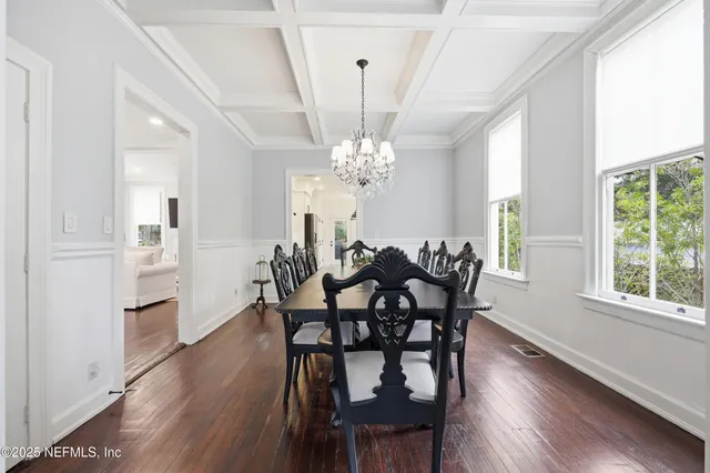 a kitchen with stainless steel appliances granite countertop a stove a sink dishwasher a refrigerator and a dining table with wooden floor