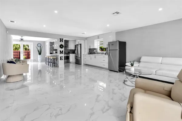 a living room with furniture and view of kitchen
